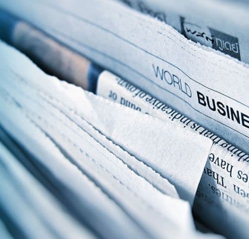 Zeitungen gestapelt, mit Schlagzeilen und Artikeln.